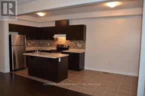 Markham (Greensborough) townhouse for rent - A kitchen with a refrigerator, sink, and cabinets.