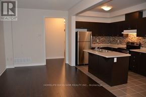 Markham (Greensborough) townhouse for rent - A kitchen with dark brown cabinets and a stainless steel refrigerator.
