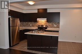 Markham (Greensborough) townhouse for rent - A kitchen with a refrigerator, sink, and stove.