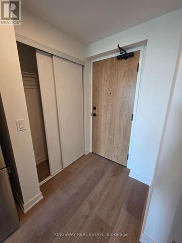 Brantford condo for rent - A kitchen with a refrigerator and a wooden door.