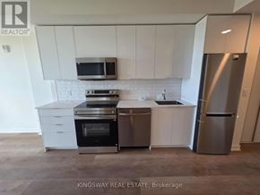 Brantford condo for rent - A kitchen with white cabinets and stainless steel appliances.
