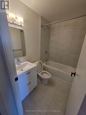 Brantford condo for rent - A white bathroom with a sink, toilet and bathtub.
