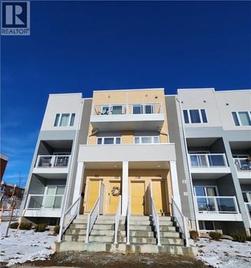 Kitchener condo for rent - A modern apartment building with a clear blue sky in the background.