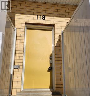 Kitchener condo for rent - A yellow door with a black handle and a number 118 above it.