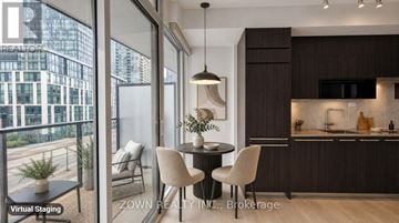 Toronto (Waterfront Communities) condo for rent - A modern kitchen with dark wood cabinets and a dining table with four chairs.