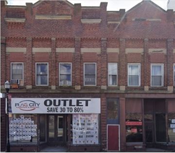 Mccomb apartment for rent - A red brick building with a sign that says "RJCITY OUTLET SAVE 30 TO 80%".
