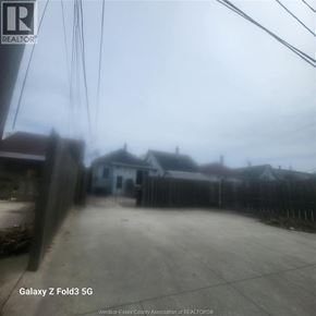 Windsor apartment for rent - A realtor's photo of a residential area with houses and a fence.