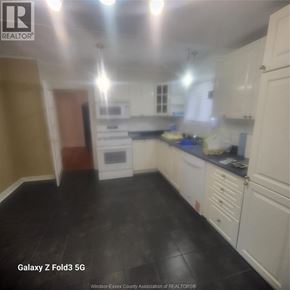 Windsor apartment for rent - A kitchen with white cabinets and black flooring.