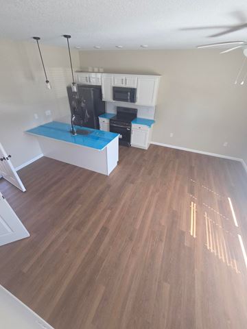 Lima apartment for rent - A kitchen with a blue counter top and wooden floors.
