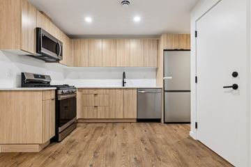 Edmonton apartment for rent - A kitchen with wooden cabinets and a white door.