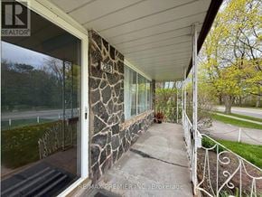 St. Catharines (Fairview) apartment for rent - A stone wall with a glass door and a metal fence.