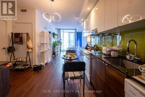 Toronto (Bayview Village) condo for rent - A kitchen with a black chair and wooden floors.
