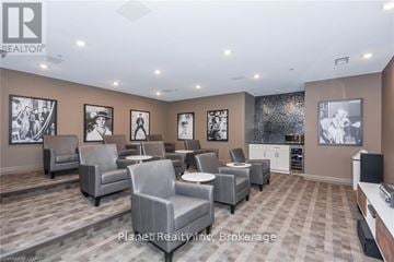 Guelph (Downtown) condo for rent - A living room with a grey sofa set and a television.
