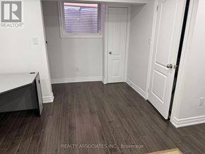 Toronto (Rouge) apartment for rent - A room with a wooden floor and white walls.