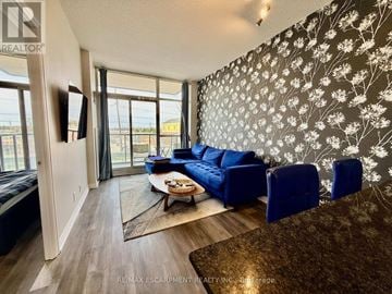 Burlington (Uptown) condo for rent - A living room with a blue couch and a coffee table.