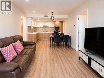 Richmond apartment for rent - A living room with a brown leather couch and a wooden floor.
