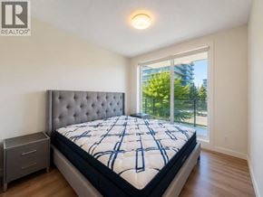 Richmond apartment for rent - A bedroom with a large bed and a window overlooking a balcony.