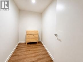 Richmond apartment for rent - A bedroom with a wooden chest of drawers and a white wall.