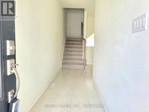 Thorold (Confederation Heights) townhouse for rent - A hallway with a staircase leading to a door.