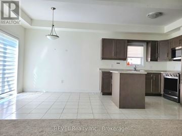 Thorold (Confederation Heights) townhouse for rent - A kitchen with a brown island and brown cabinets.