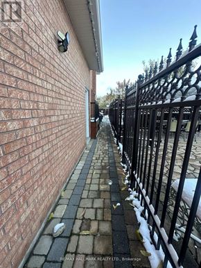 Toronto (Rustic) apartment for rent - A brick wall with a black iron fence in front of it.