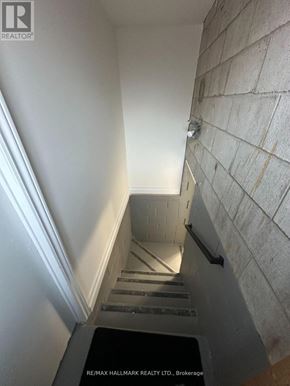 Toronto (Rustic) apartment for rent - A stairway with a black mat at the bottom.