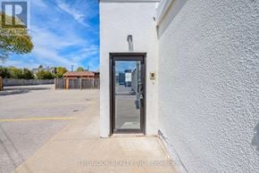 Oshawa (Centennial) condo for rent - A white building with a glass door and a small window above it.