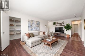 Oshawa (Centennial) condo for rent - A living room with a white couch, a coffee table, and a painting on the wall.