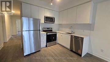 St. Catharines (E. Chester) townhouse for rent - A kitchen with white cabinets and stainless steel appliances.