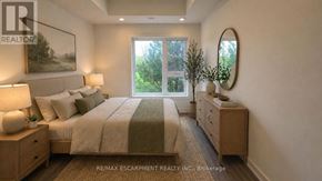 St. Catharines (E. Chester) townhouse for rent - A bedroom with a large bed, nightstands, and a painting on the wall.