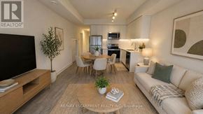 St. Catharines (E. Chester) townhouse for rent - A living room with a flat screen TV, a couch, a dining table, and a potted plant.