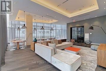Toronto (Waterfront Communities) condo for rent - A modern living room with a white sofa and a wooden coffee table.