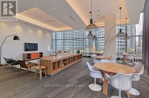 Toronto (Waterfront Communities) condo for rent - A modern dining room with a long table and chairs.