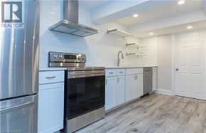 Dundas apartment for rent - A modern kitchen with stainless steel appliances and white cabinetry.