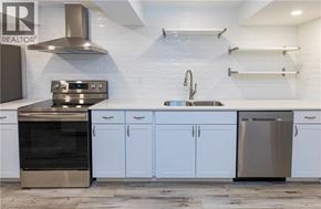 Dundas apartment for rent - A modern kitchen with white cabinets and stainless steel appliances.