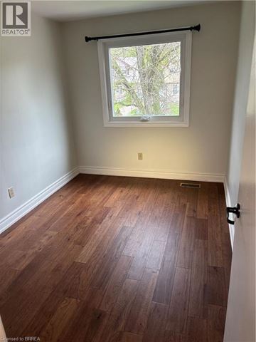 Guelph apartment for rent - A room with wooden flooring and a window.