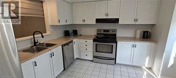 Hamilton townhouse for rent - A kitchen with white cabinets and a black stove top oven.