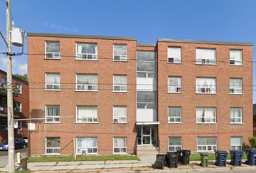 East York apartment for rent - A red brick building with a white door and windows.