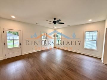 Huntsville apartment for rent - A spacious room with a ceiling fan and wooden flooring.