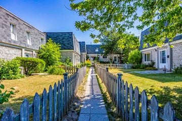 Mississauga apartment for rent - A sunny day in a quiet neighborhood with a wooden fence and houses on both sides.
