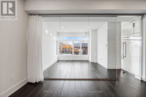 Ottawa apartment for rent - A spacious room with wooden floors and white walls.