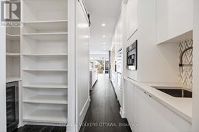 Ottawa apartment for rent - A modern kitchen with white cabinets and a black refrigerator.