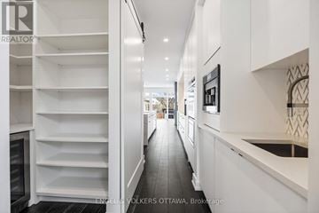 Ottawa apartment for rent - A modern kitchen with white cabinets and a black refrigerator.