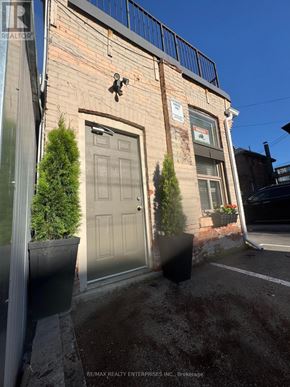 Hamilton (Durand) apartment for rent - A building with a grey door and a sign on the wall.