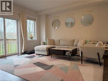 Waterdown townhouse for rent - A living room with a white couch, a coffee table, and a rug with a geometric pattern.
