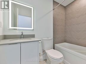 Toronto (L'amoreaux) townhouse for rent - A white toilet is in a bathroom with a sink and mirror.
