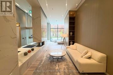 Burlington (Brant) condo for rent - A spacious living room with a white sofa and a coffee table.