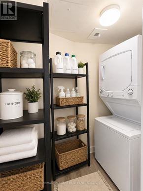 Toronto (Waterfront Communities) condo for rent - A laundry room with a washer and dryer, and a shelf with laundry supplies.