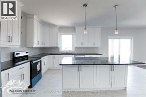Chatham apartment for rent - A kitchen with white cabinets and black countertops.