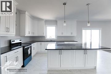 Chatham apartment for rent - A kitchen with white cabinets and black countertops.